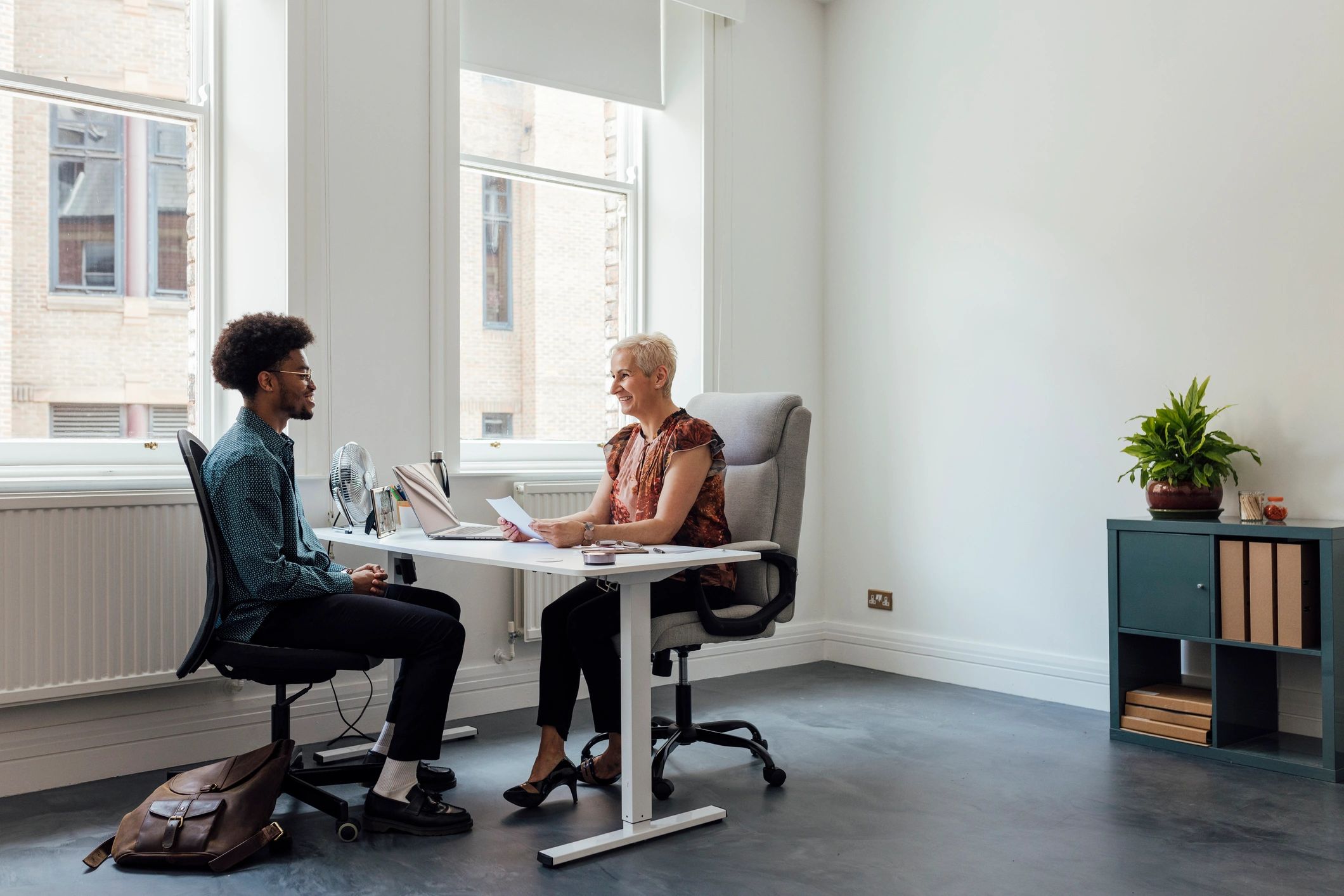 Two professionals meeting in an office to discuss a client matter