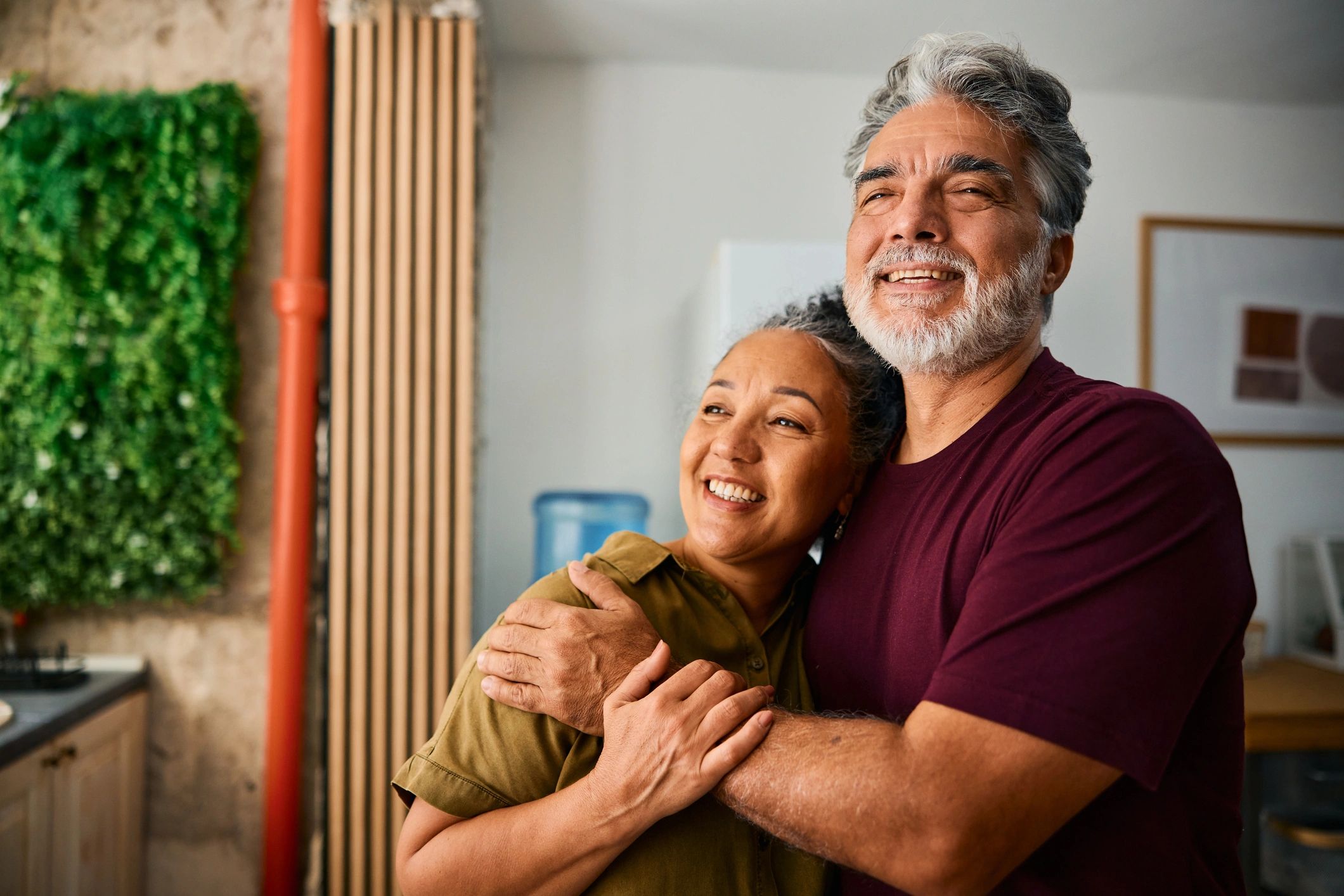 Happy senior couple embracing and smiling at home